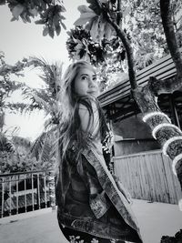 Girl standing by tree against plants