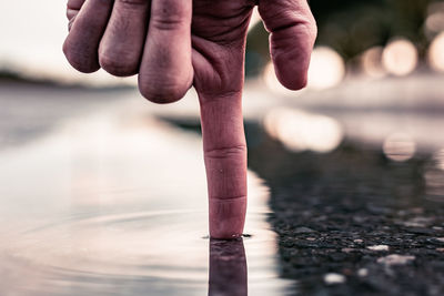 Close-up of hands on water