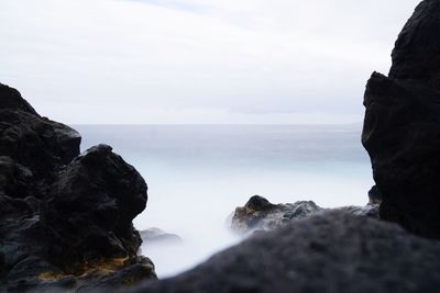 Scenic view of rock formation and sea against sky