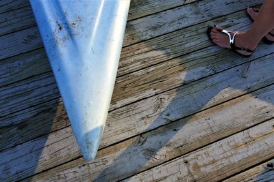 Low section of woman with umbrella on wood