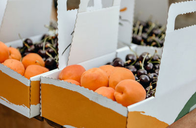 Close-up photo fresh apricots and cherries in box