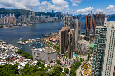 High angle view of buildings by city against sky