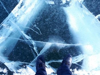 Low section of person standing by water