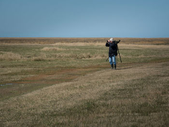 Full length of man standing on field against sky