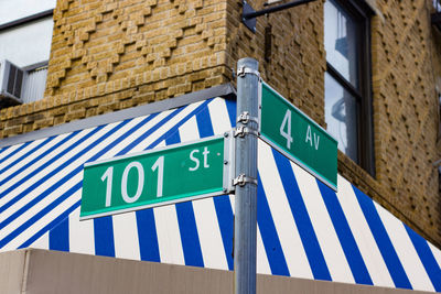 Low angle view of road sign against building