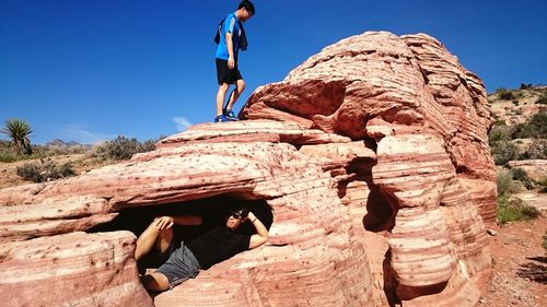 Low angle view of man standing on rock formation