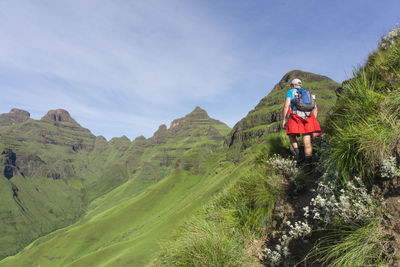 Rear view of woman by mountains against sky