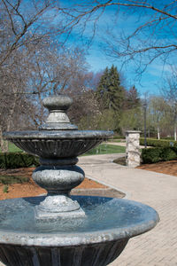 Fountain by trees against sky