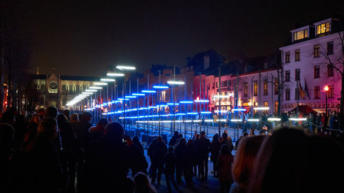 Group of people in illuminated city at night