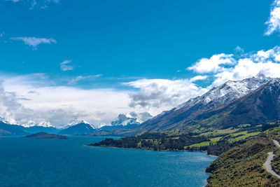 Scenic view of lake and mountains against blue sky