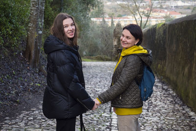 Adult mother and her daughter walk in the park