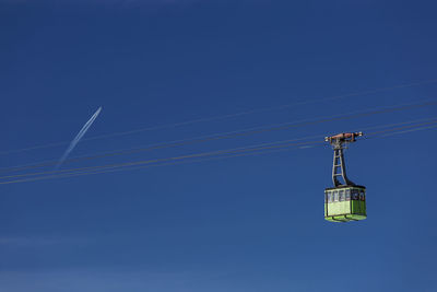 Low angle view of overhead cable car against blue sky