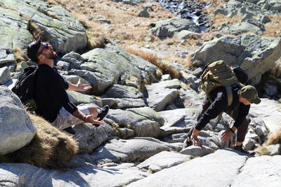 Side view of men on rock