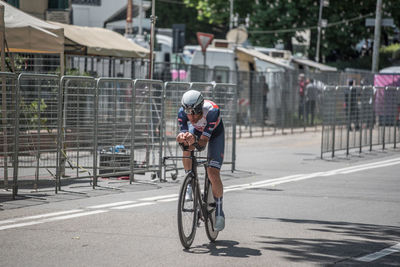 Man riding bicycle on road in city