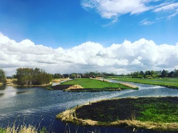 Scenic view of river against cloudy sky