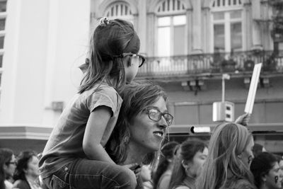 Close-up of mother and girl sitting on floor