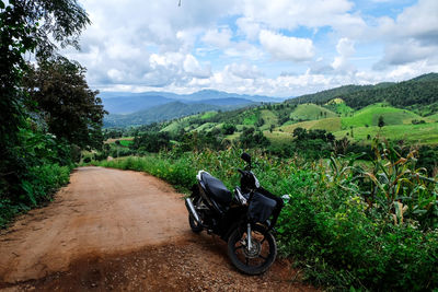 Motorcycle on road by mountain against sky