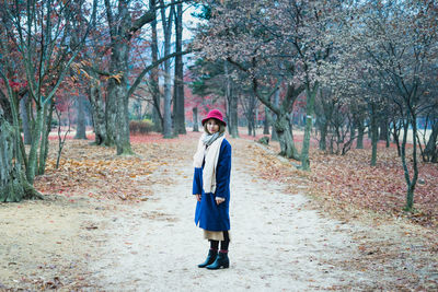 Full length of woman standing in forest