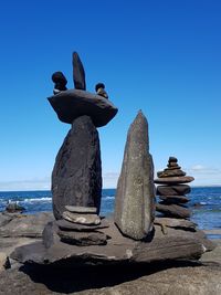 Statue on beach against clear blue sky