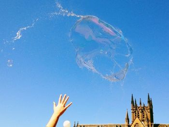 Low angle view of woman against blue sky