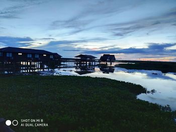 Scenic view of lake by buildings against sky