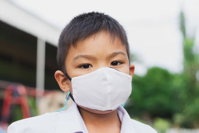 Close-up portrait of boy wearing mask outdoors