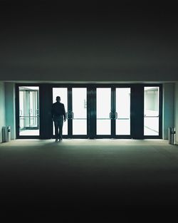 Silhouette man walking in corridor of building