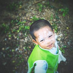 Portrait of cute boy with messy face standing on field