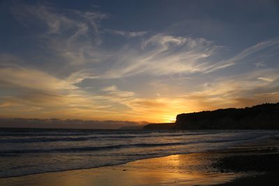 Scenic view of beach against sky during sunset