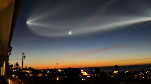 Illuminated city against sky at night