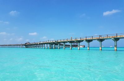 Bridge over sea against blue sky