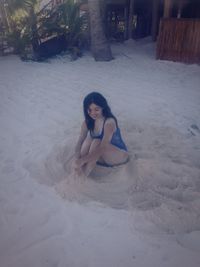 Young woman sitting on sand
