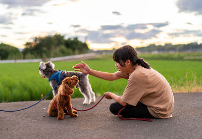 Side view of woman with dog on field