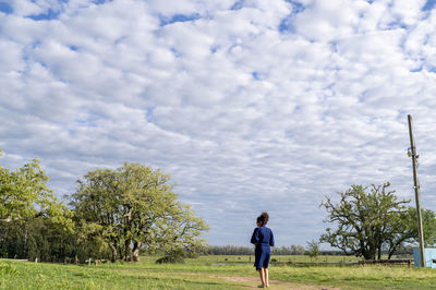 Rear view of woman walking on field