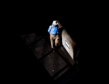 Rear view of woman standing on tiled floor