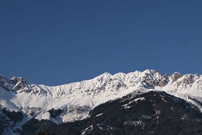 Scenic view of snowcapped mountains against clear blue sky