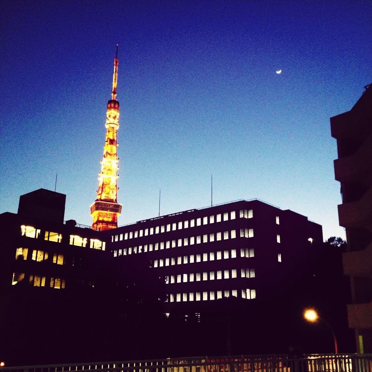 LOW ANGLE VIEW OF ILLUMINATED TOWER AT NIGHT