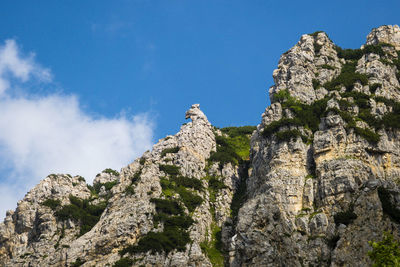 Low angle view of rocks against blue sky