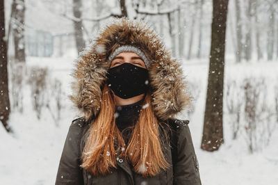 Portrait of young woman covered with snow