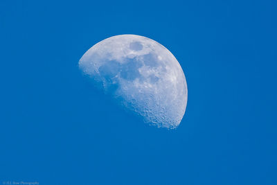 Low angle view of moon against clear blue sky