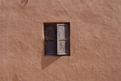 Close-up of window on wall of old building
