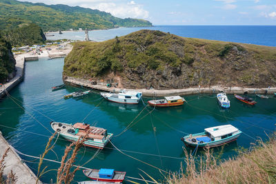 High angle view of sailboats moored on sea against sky