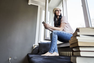 Smiling young woman sitting at the window