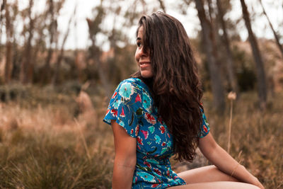 Woman sitting on land in forest