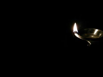 Close-up of lit candle in the dark