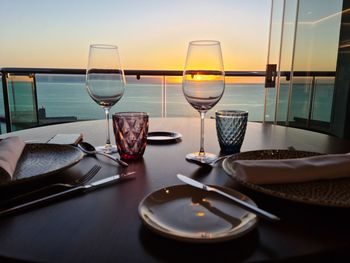 High angle view of beer on table against sea during sunset