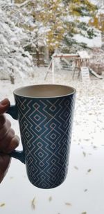 Close-up of hand holding coffee cup