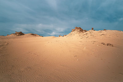 Sand dunes in desert against sky