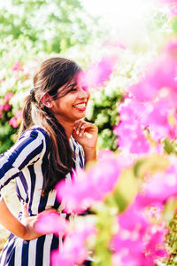 Close-up of smiling woman with pink flower