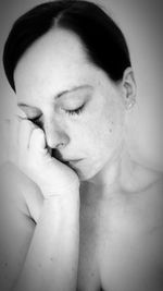 Close-up of shirtless young woman with eyes closed at home